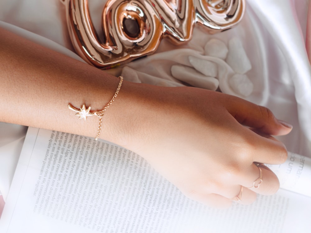 a woman's arm with a star bracelet on it