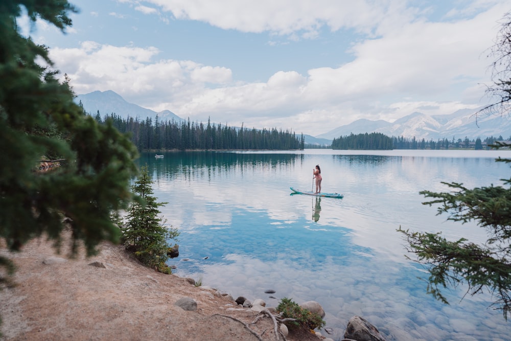 a person standing on a paddle board in a lake