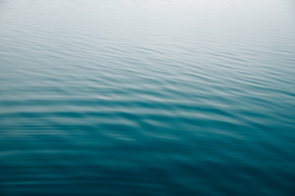 a large body of water with a boat in the distance