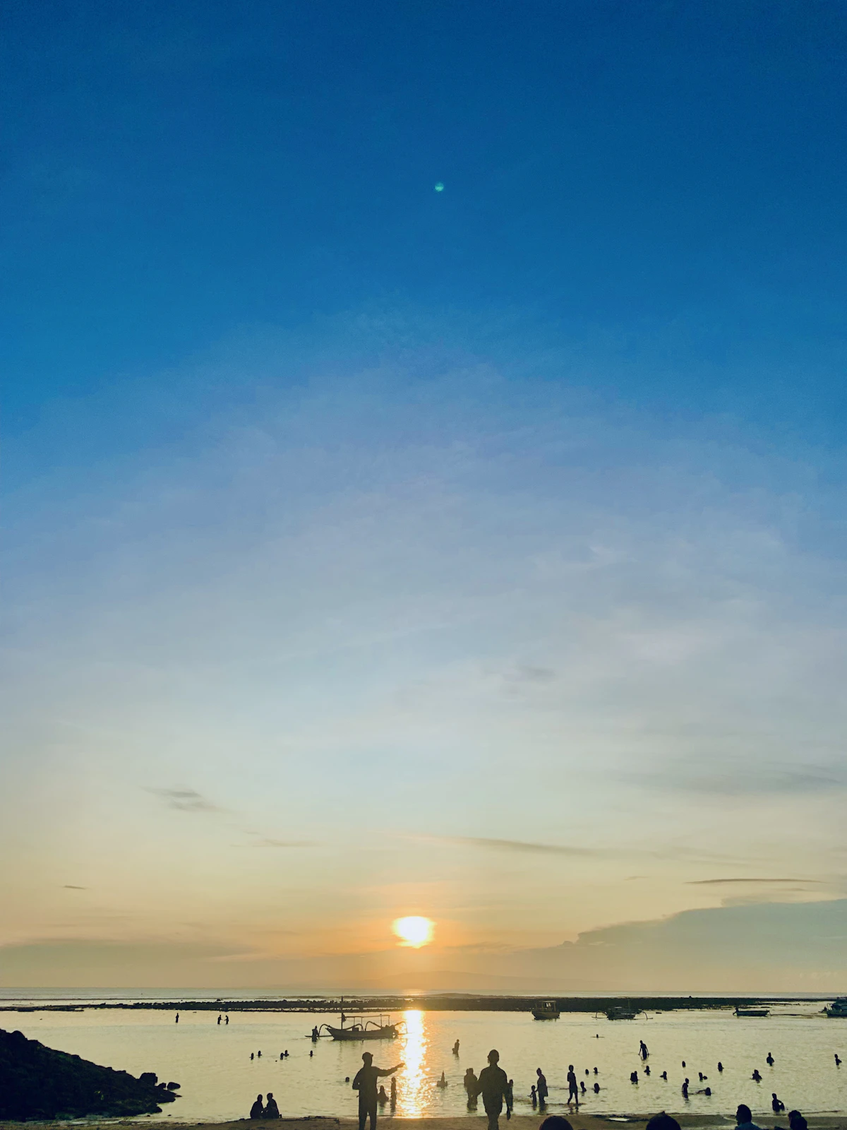 Peaceful sunrise bicycle boardwalk and calm barrier reef shallows in Sanur