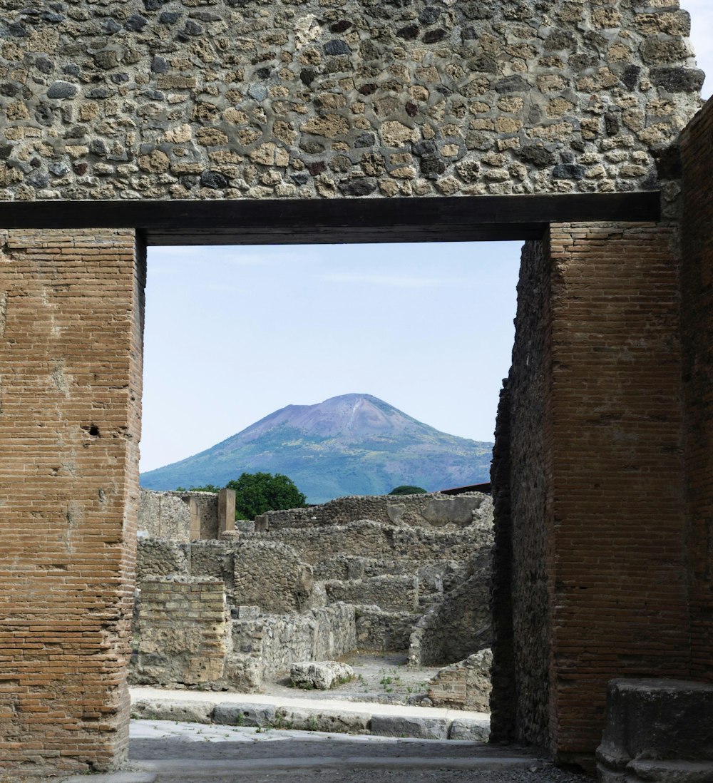 a stone building with a mountain in the background