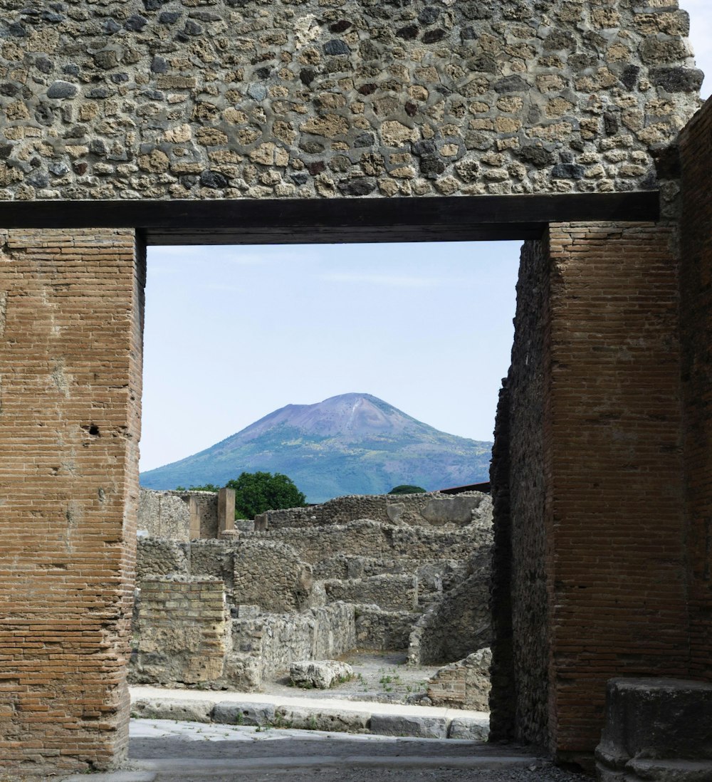 Un edificio de piedra con una montaña al fondo