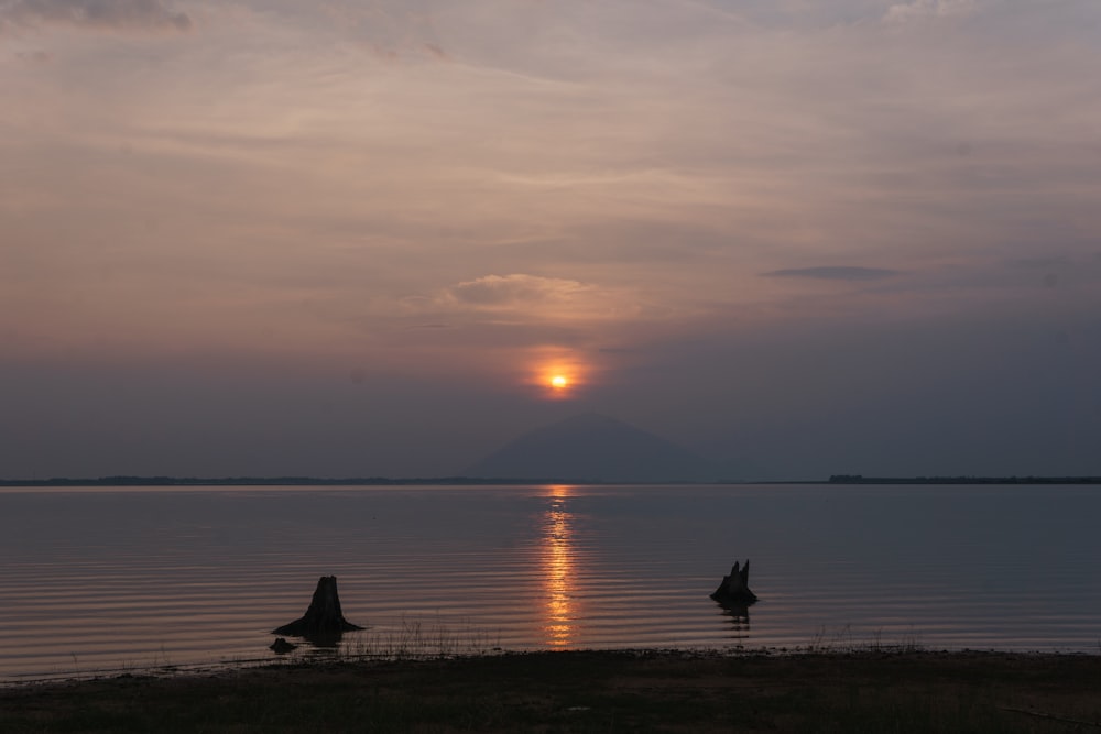 the sun is setting over a body of water