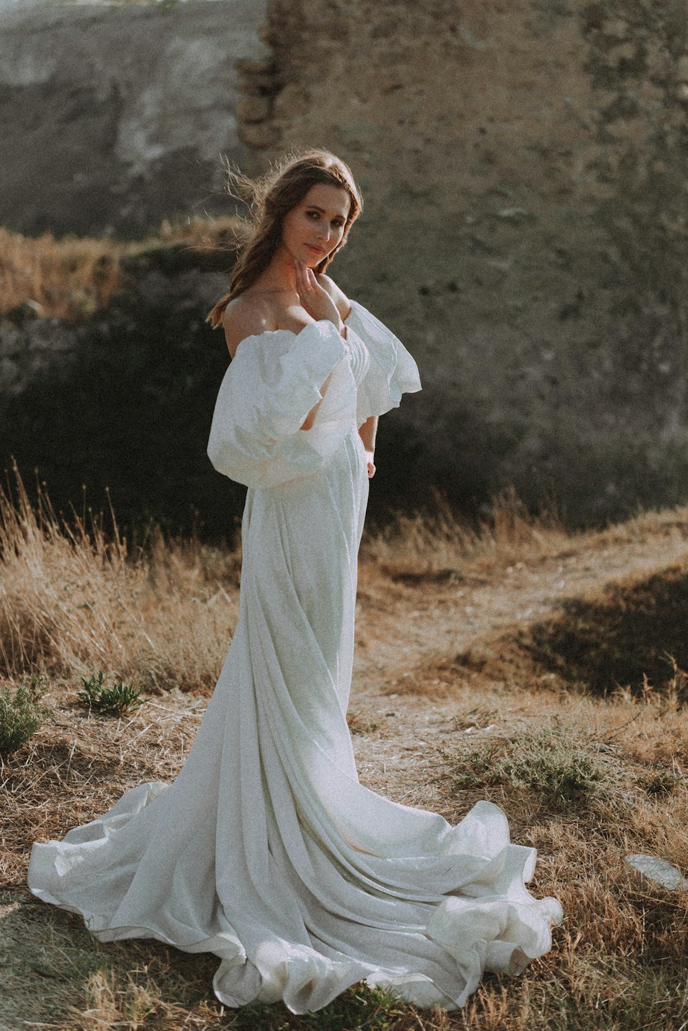 a woman in a white dress standing in a field