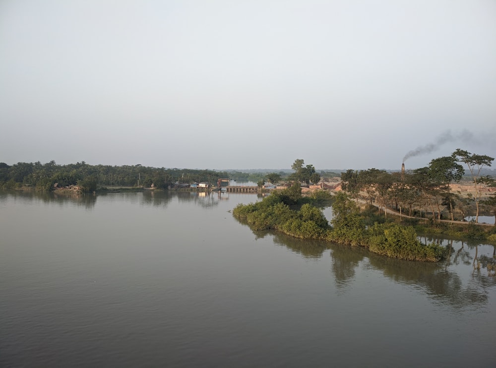 a body of water surrounded by trees and a bridge