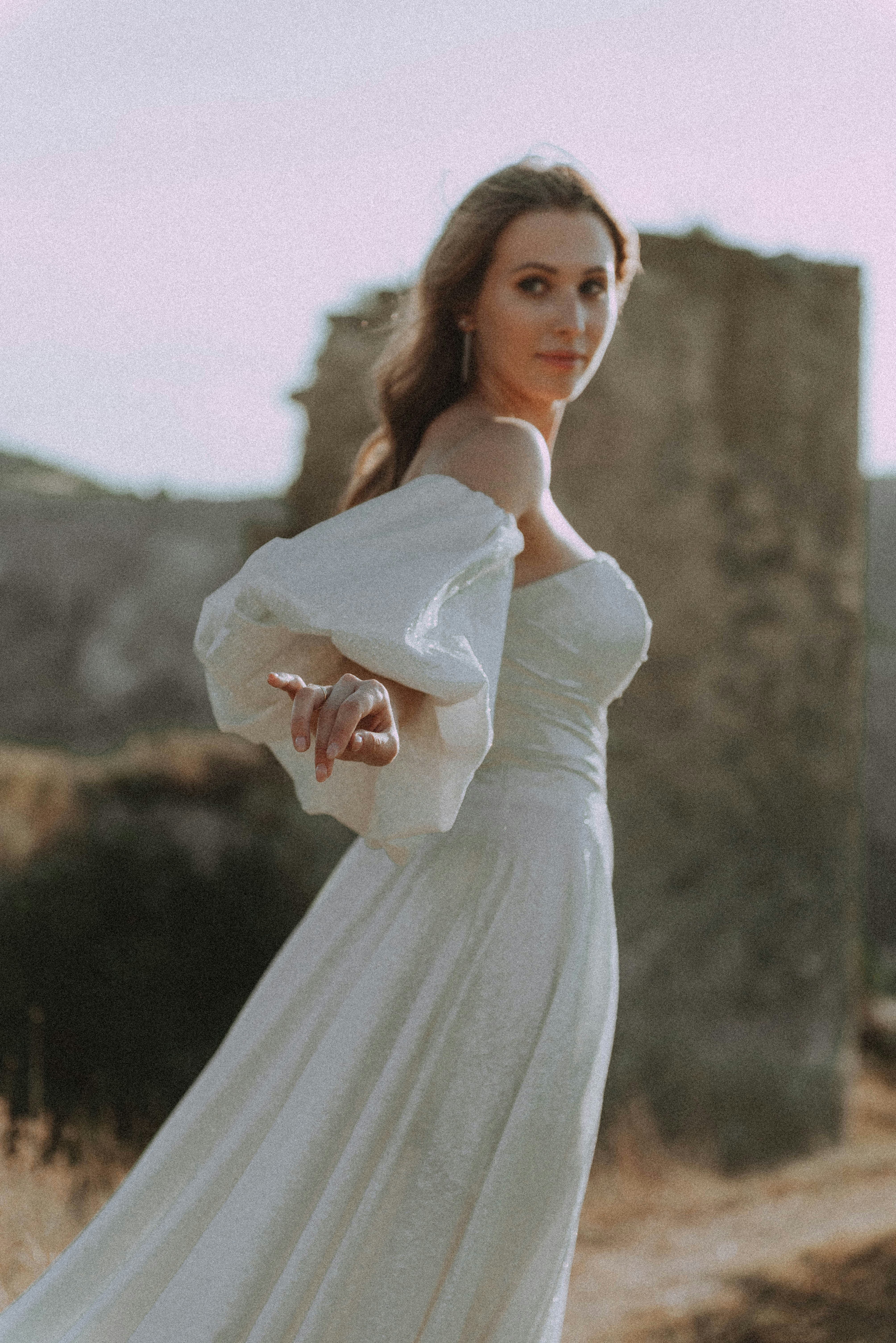 A woman in a white dress standing in a field photo – Free Grey Image on ...