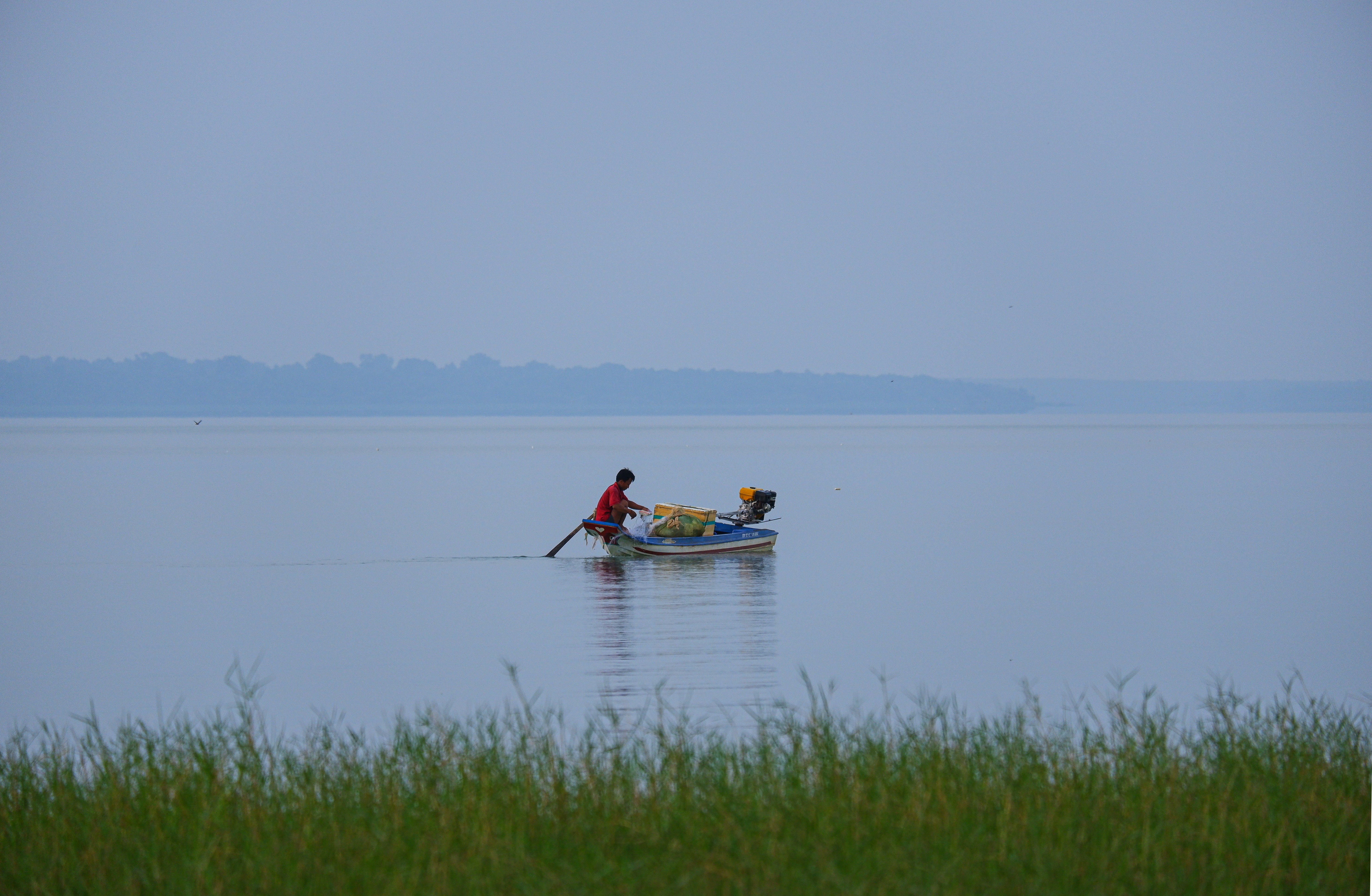 two people in a small boat on a large body of water