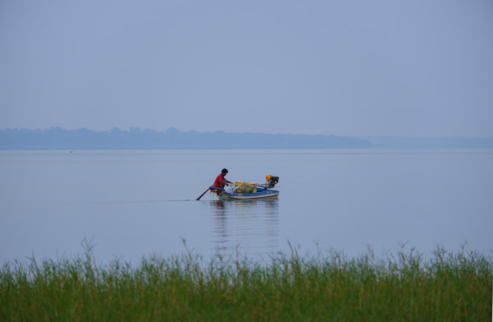 two people in a small boat on a large body of water