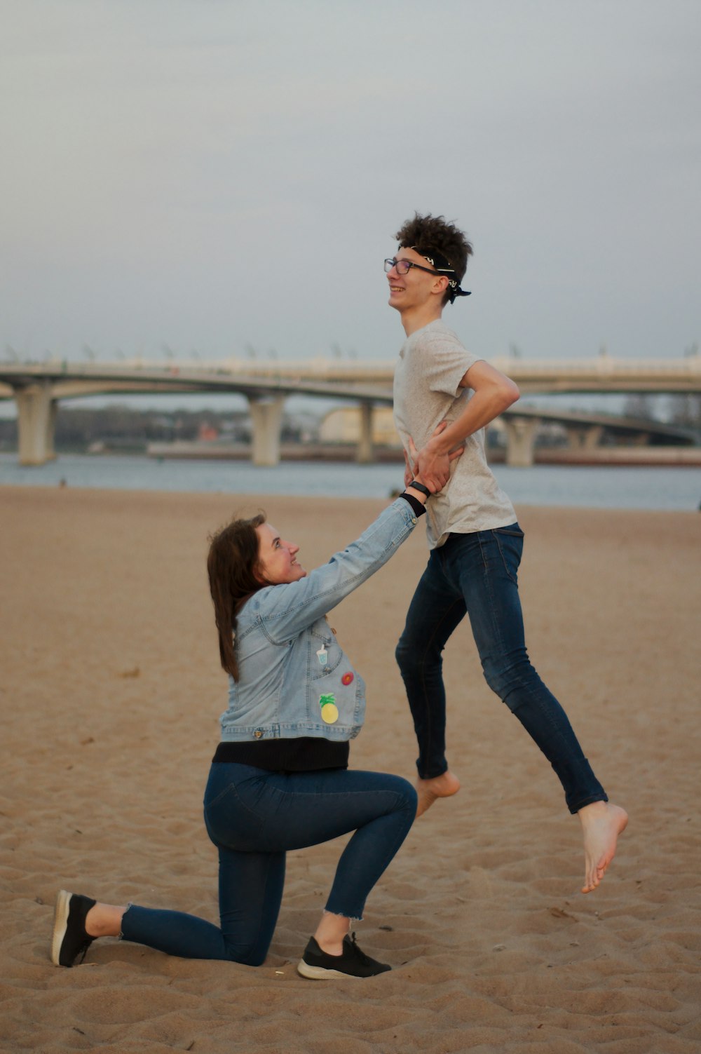 a woman is trying to catch a frisbee on the beach