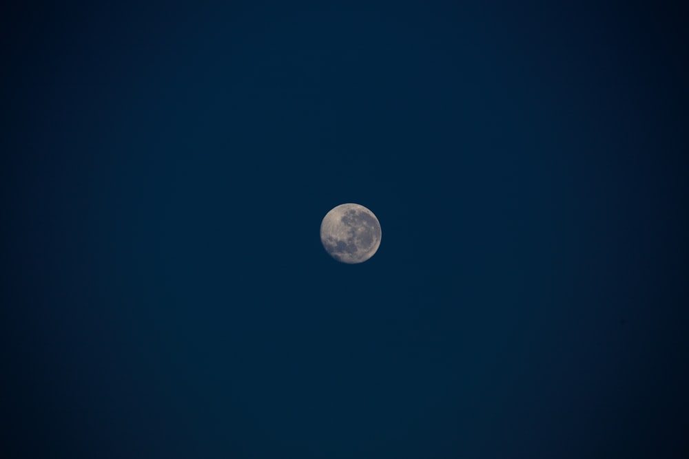 a full moon in a dark blue sky