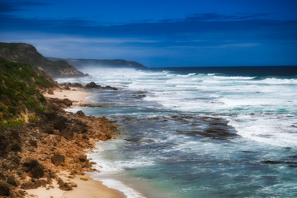 a view of a beach with waves crashing on the shore