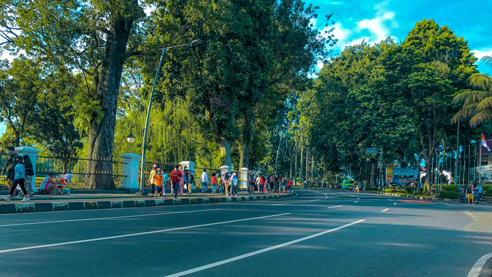 a group of people standing on the side of a road