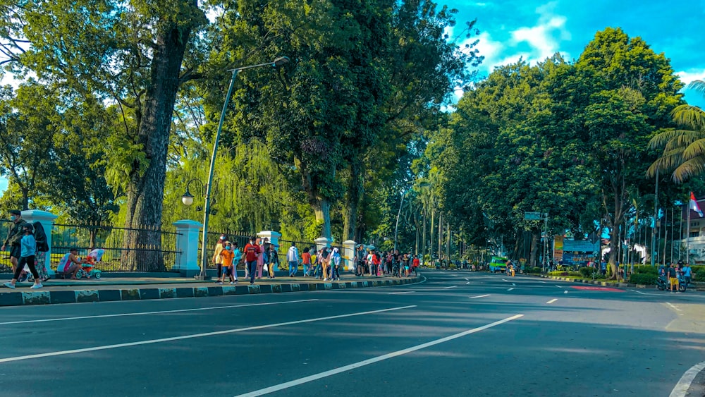 um grupo de pessoas de pé ao lado de uma estrada