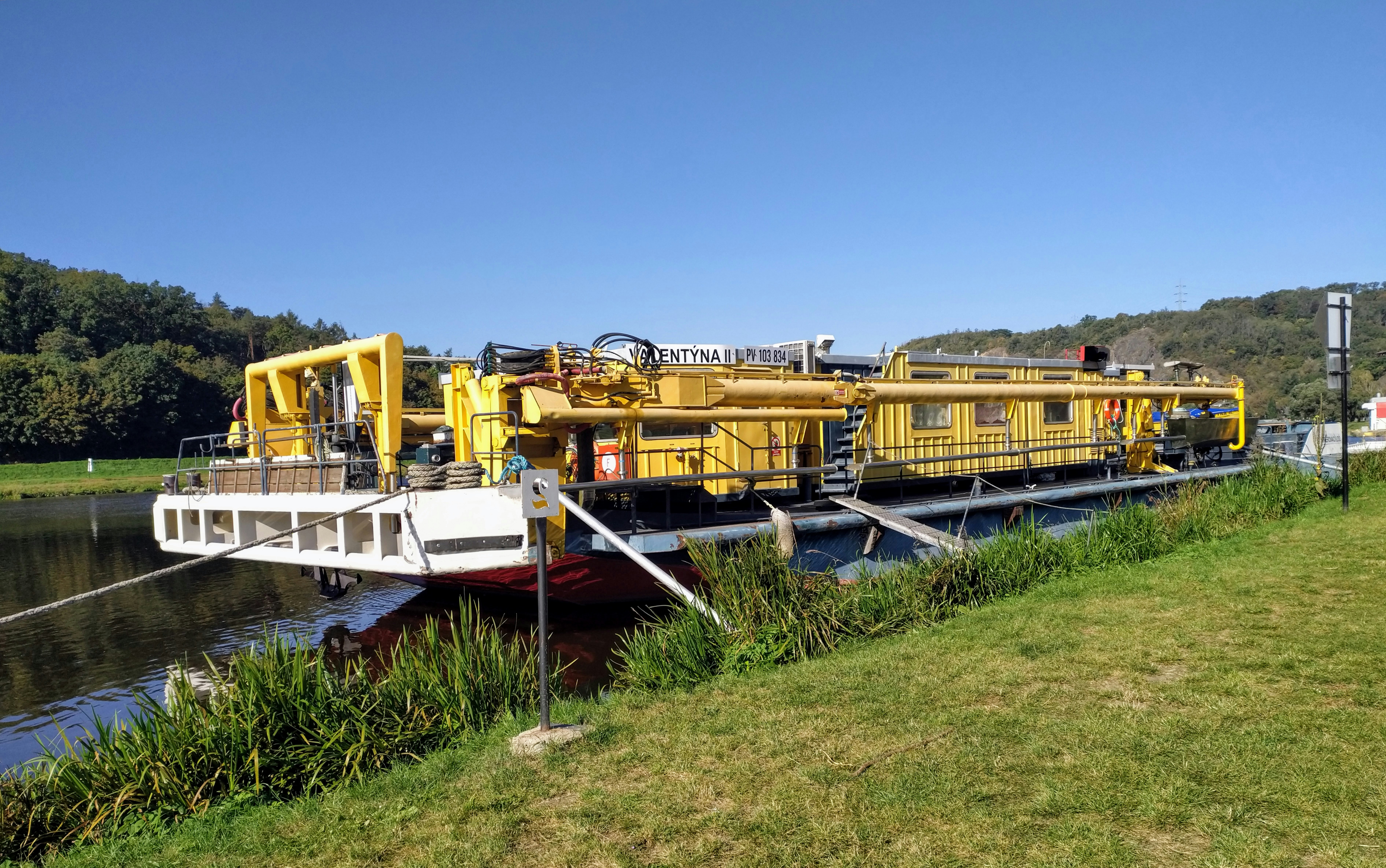 a yellow and white boat sitting on top of a body of water