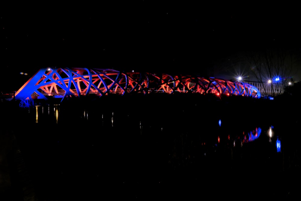 a lit up bridge over a body of water at night