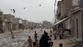 a group of people walking down a dirty street