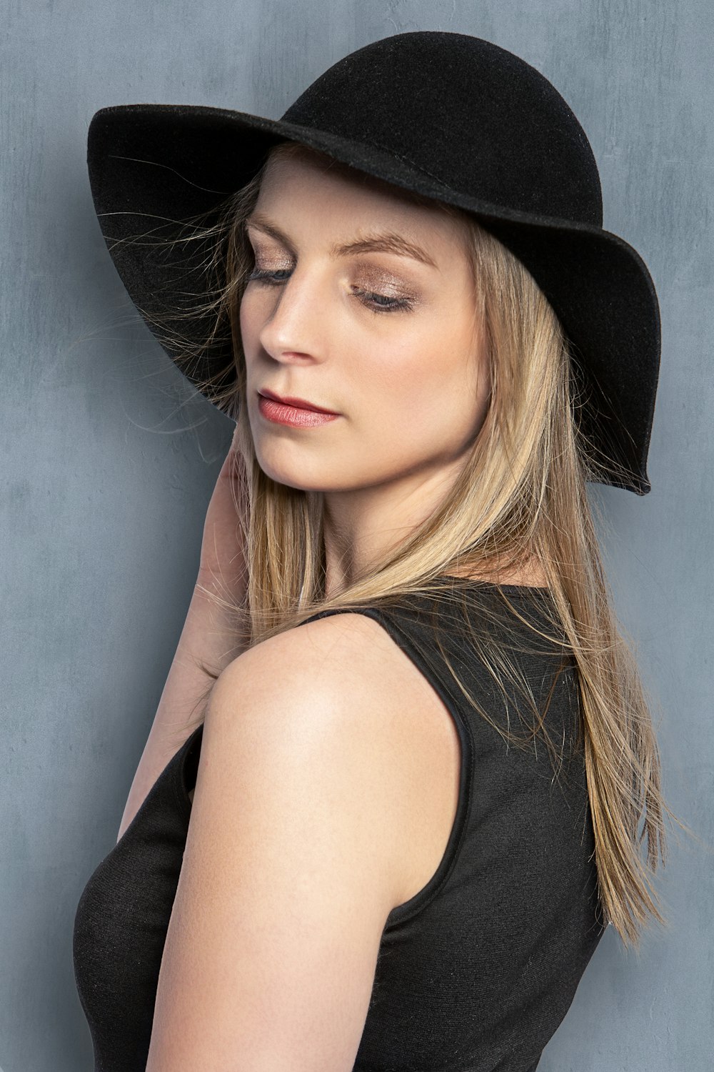 a woman in a black dress and a black hat