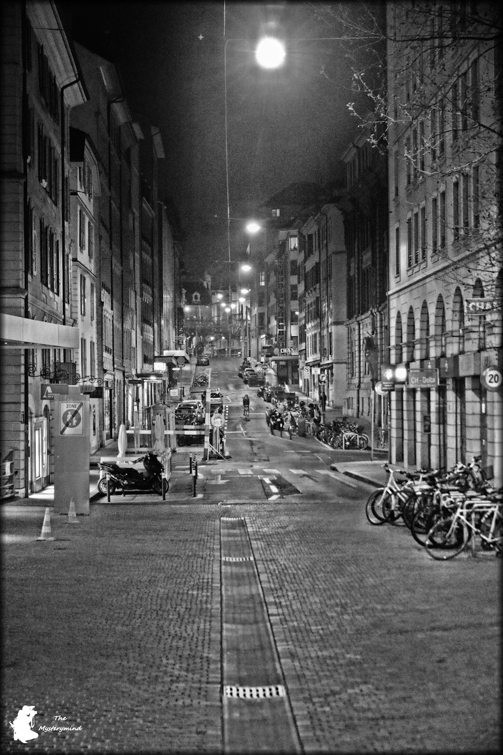 a black and white photo of a city street at night