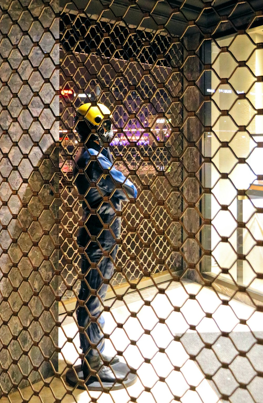 a person standing behind a chain link fence