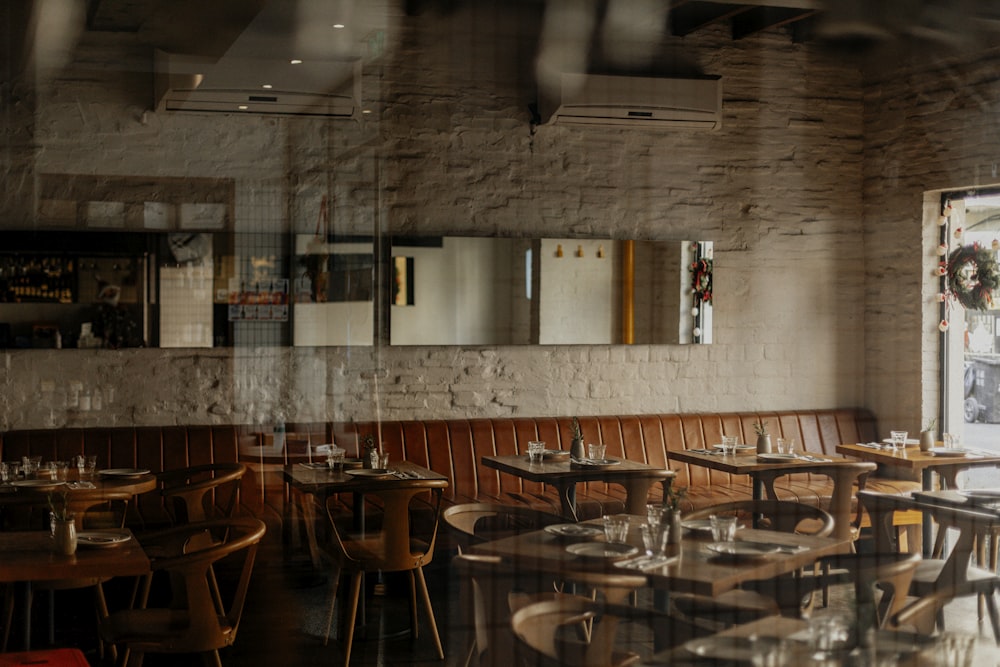 a restaurant with wooden tables and chairs and a brick wall