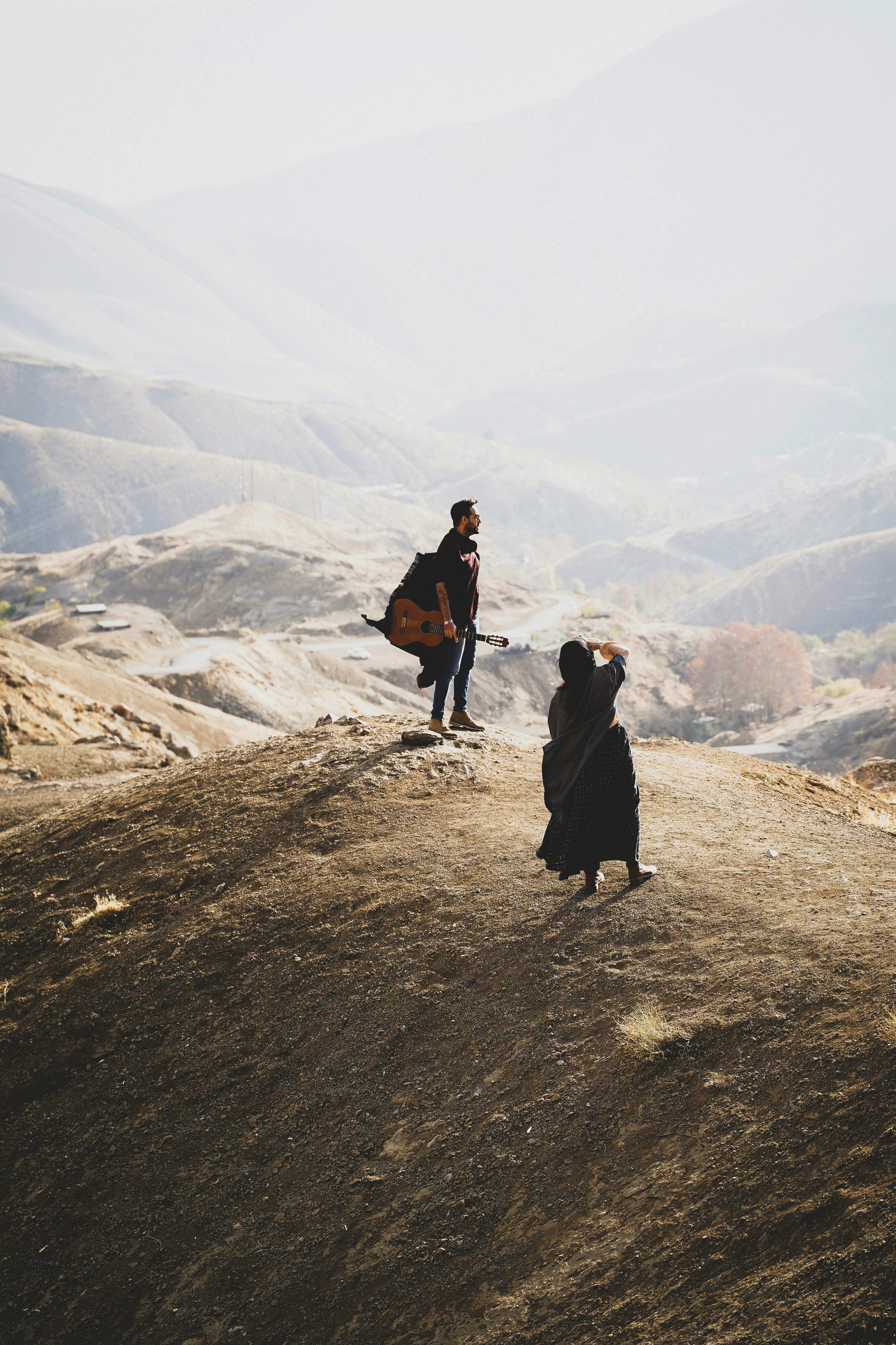 a couple of people standing on top of a hill