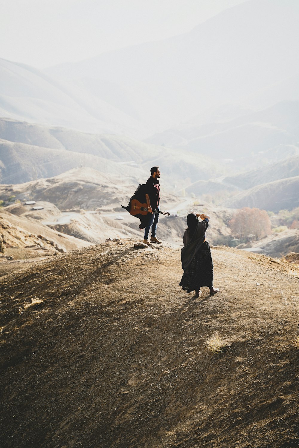 a couple of people standing on top of a hill