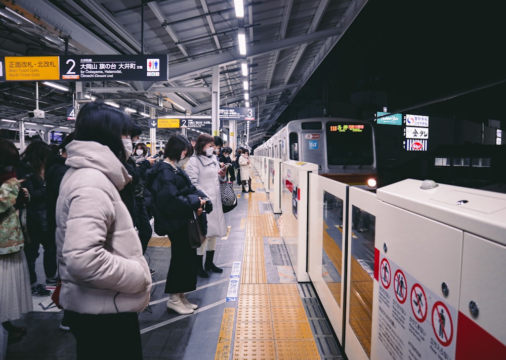 a group of people waiting at a train station