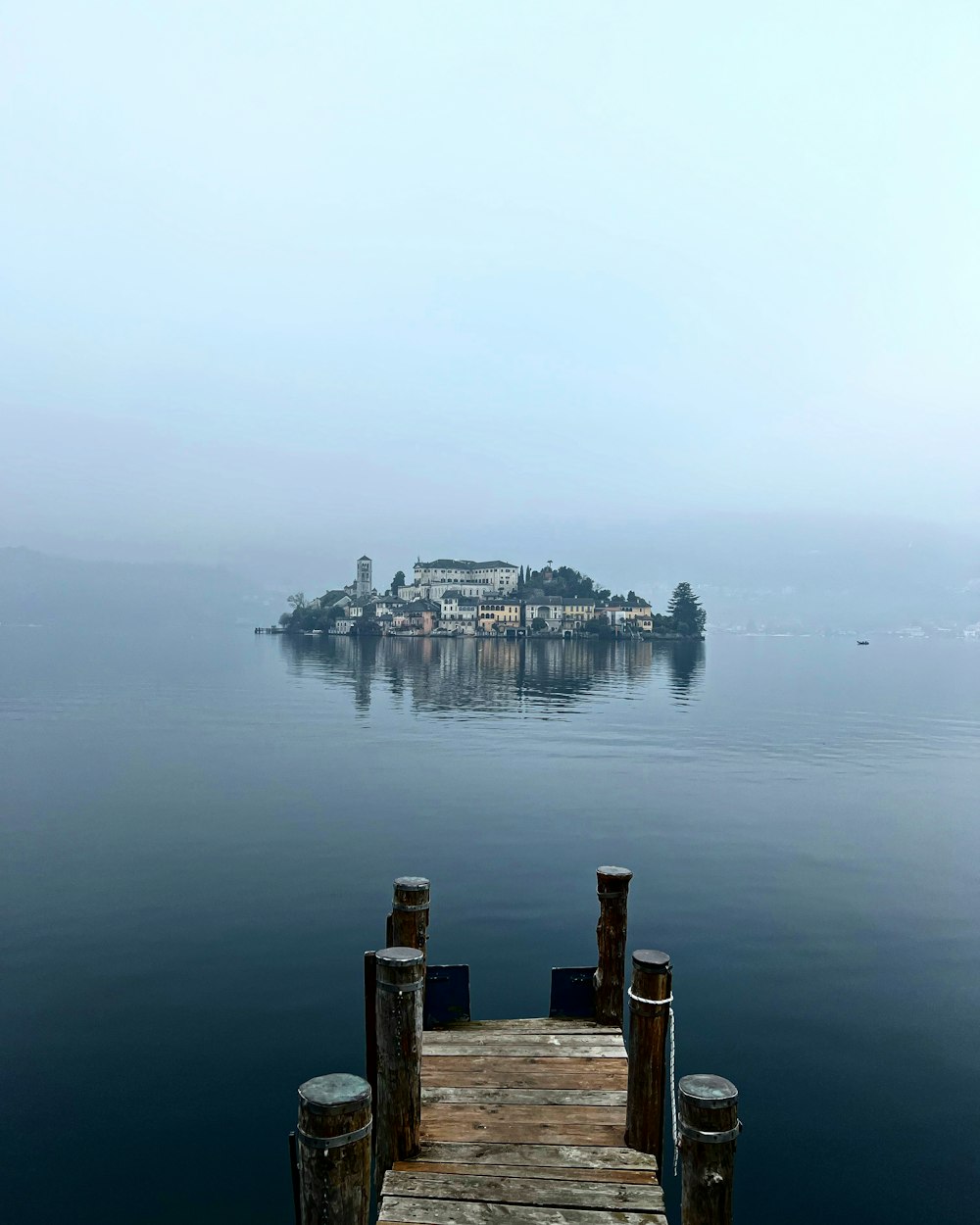 a dock on a body of water with a small island in the background