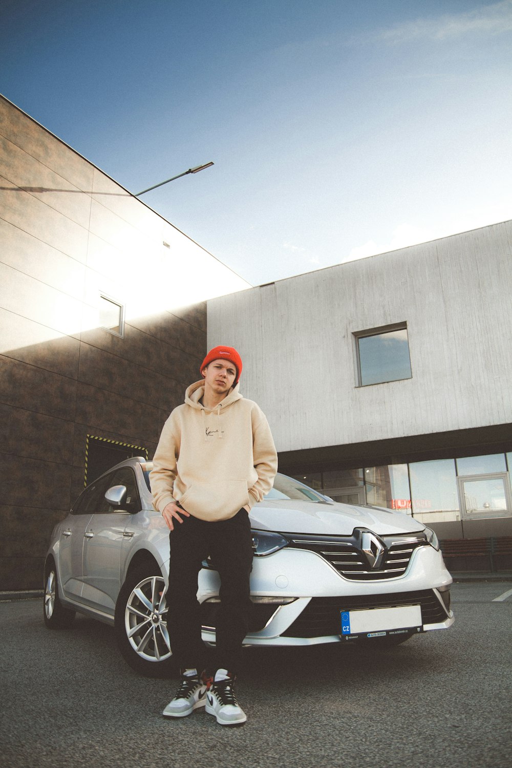 a man standing next to a silver car