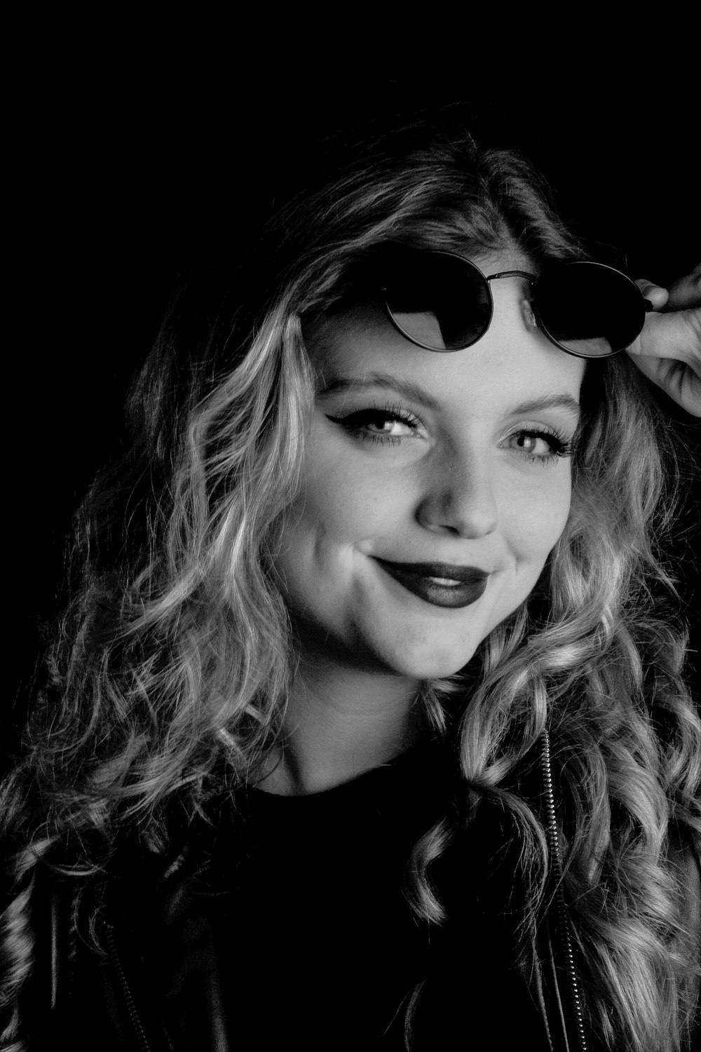 a black and white photo of a woman wearing sunglasses