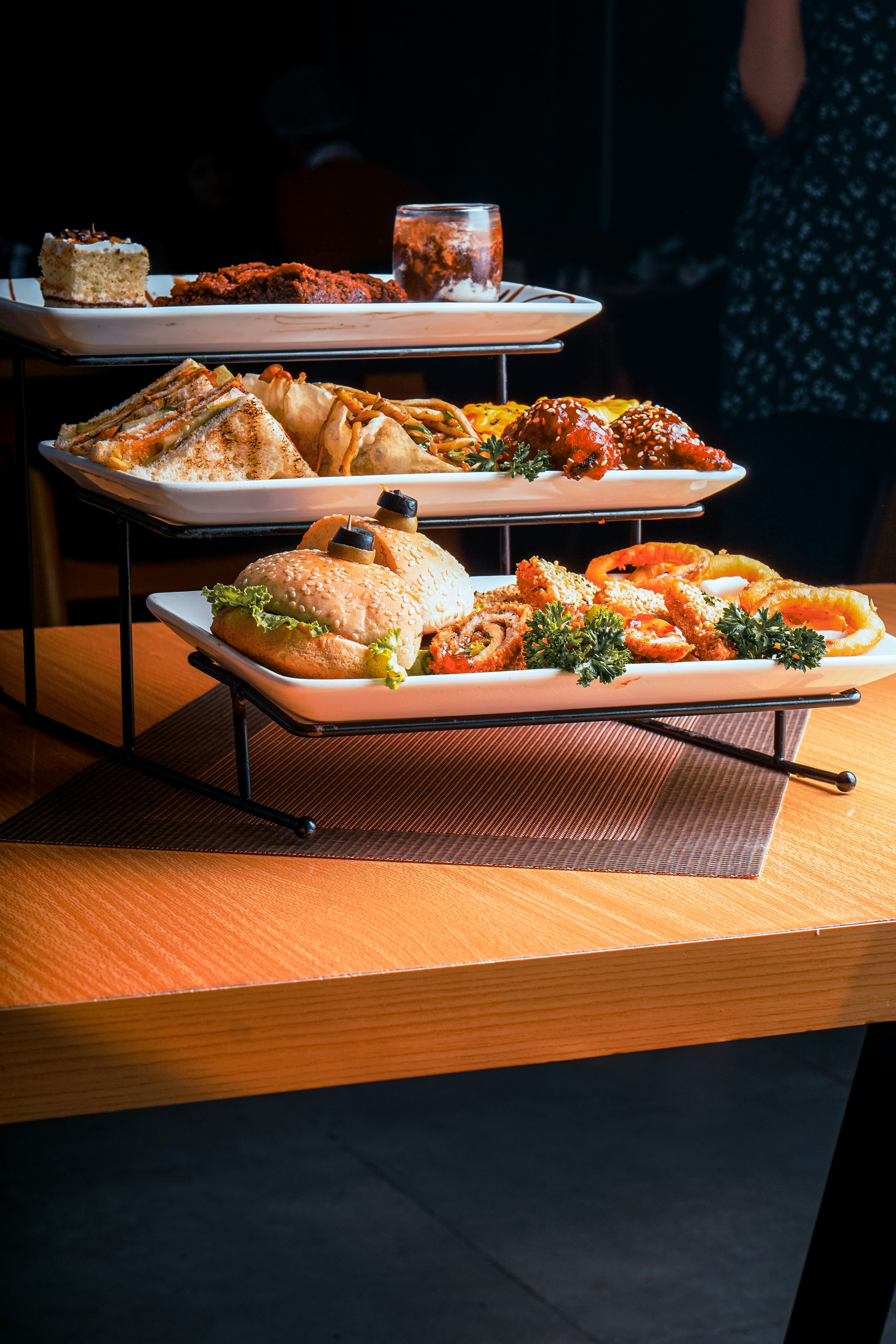a wooden table topped with three trays of food