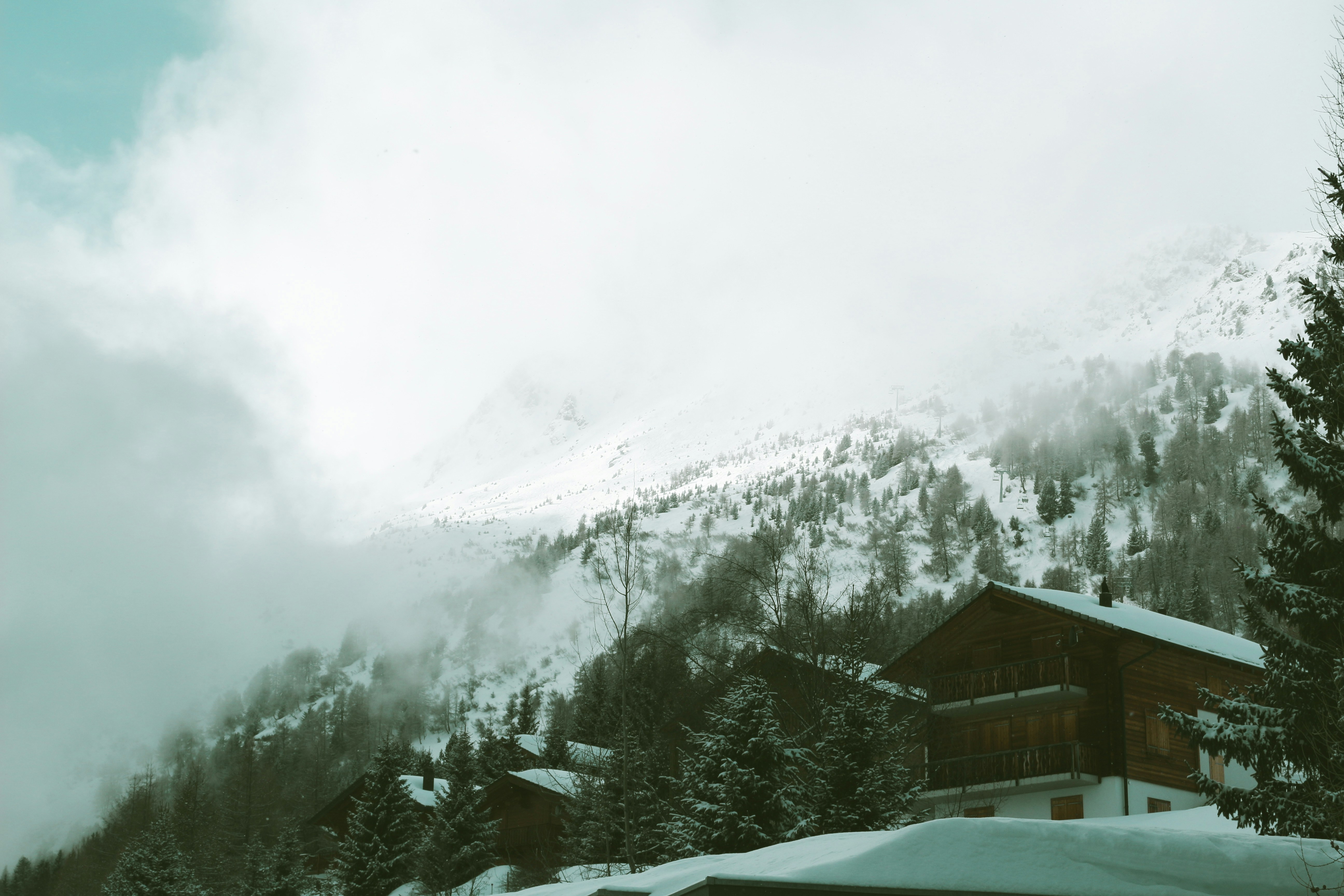 a snowy mountain with a house in the foreground