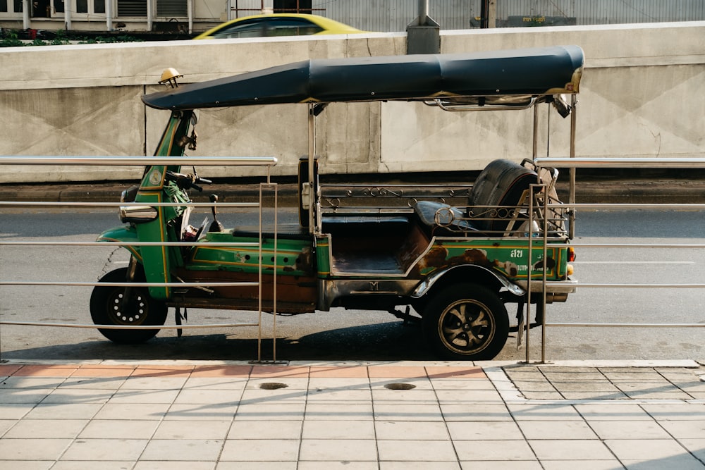 a green golf cart parked on the side of the road