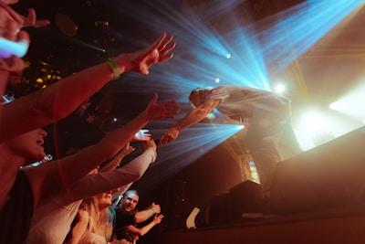 Danken passionately performing on stage under colorful lights with cheering crowd
