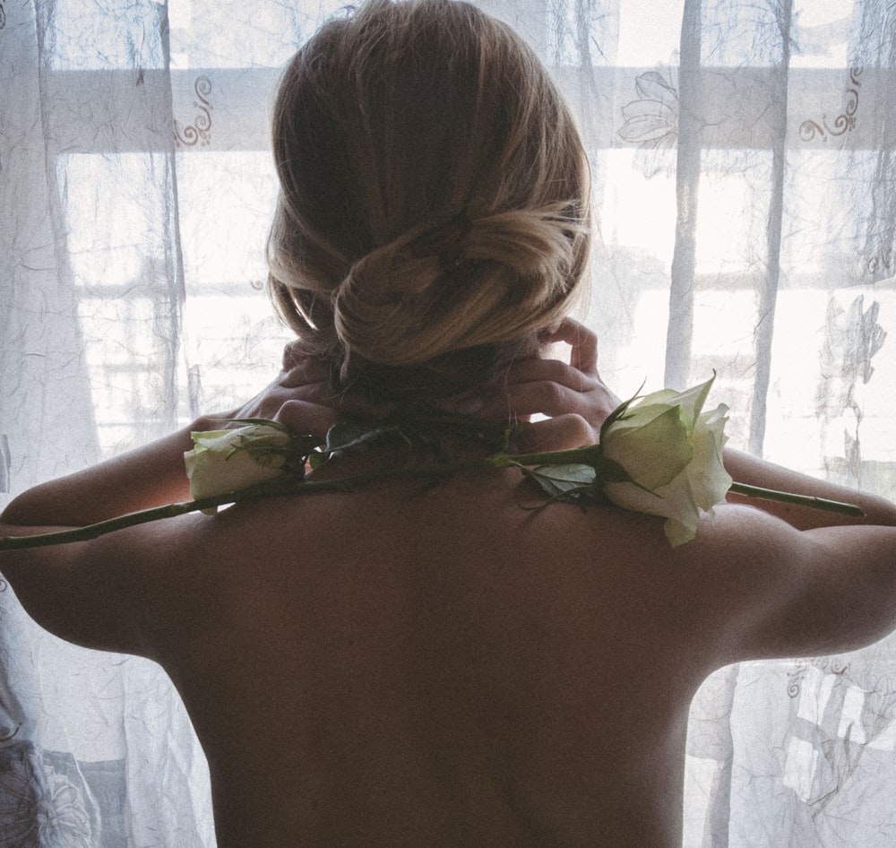the back of a woman's head with flowers in her hair