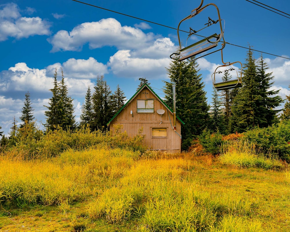 a ski lift going over a small cabin in the woods