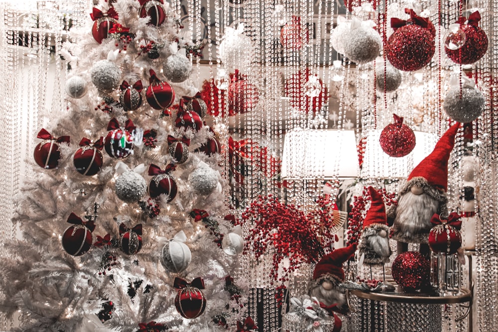 a white christmas tree with red and silver ornaments