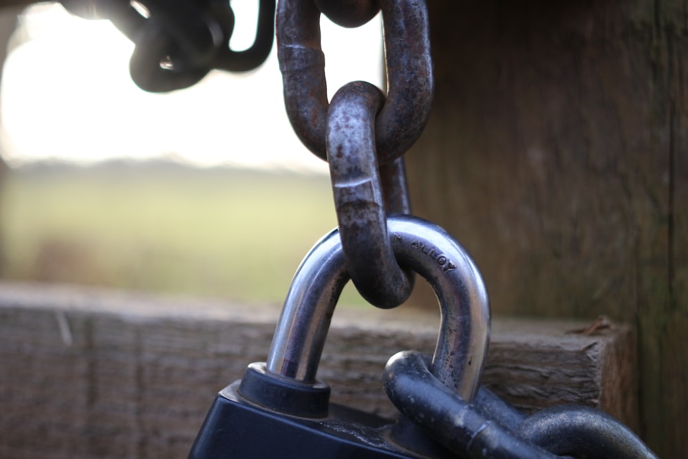 a close up of a padlock on a wooden fence