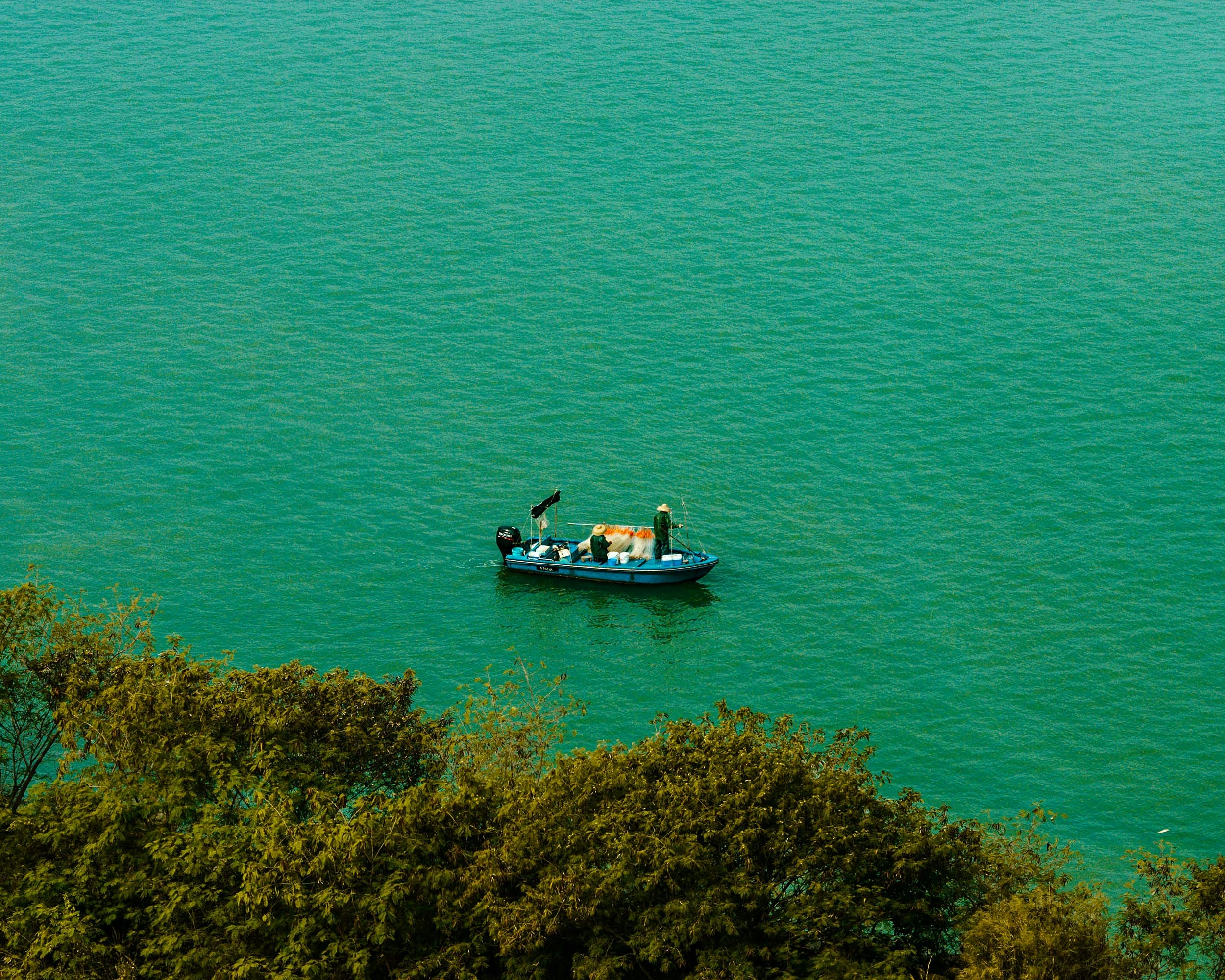 a small boat floating on top of a large body of water