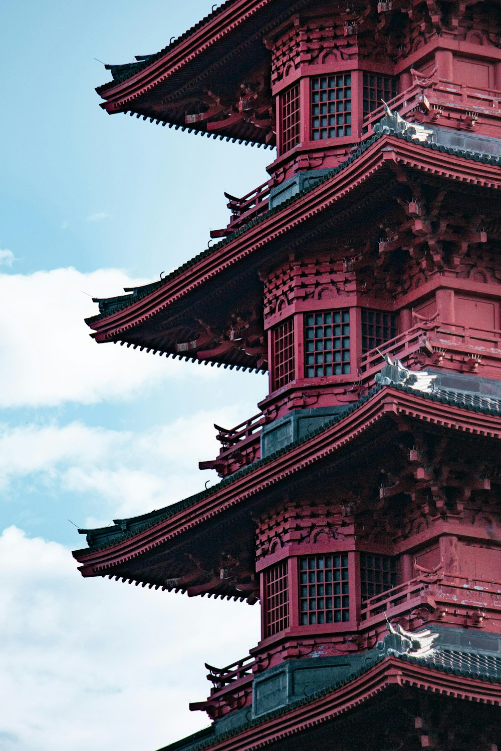 a tall red tower with a clock on the top of it