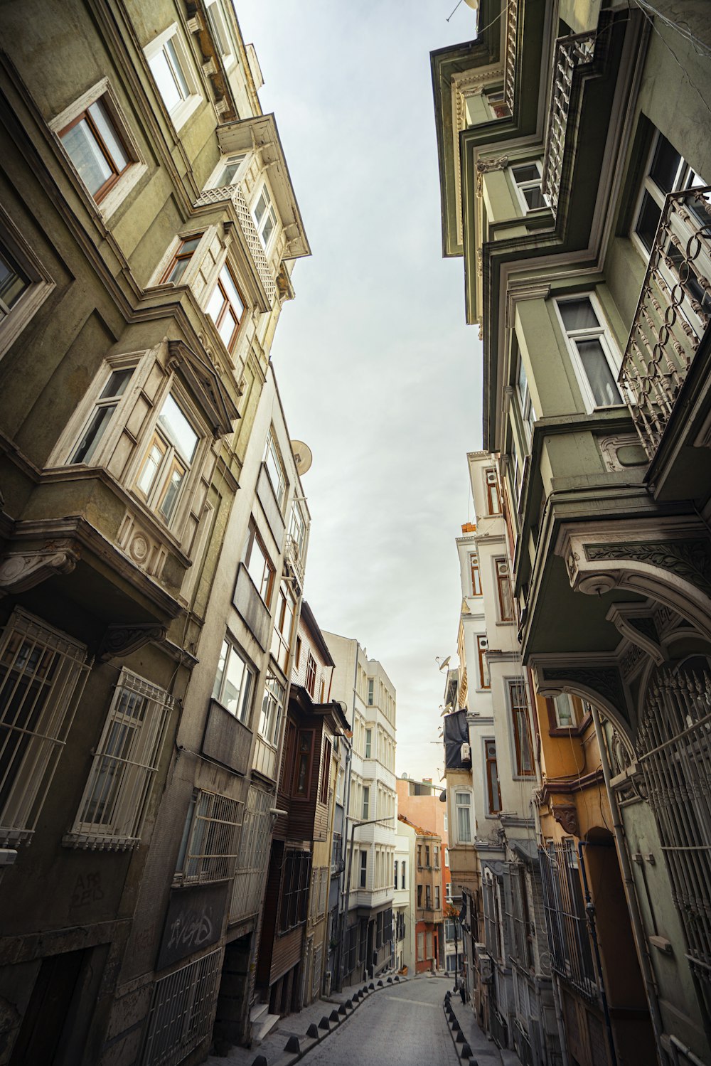 a narrow city street with lots of windows and balconies