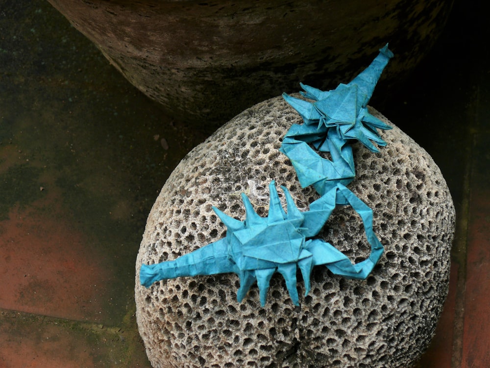 a rock with some blue origami on it