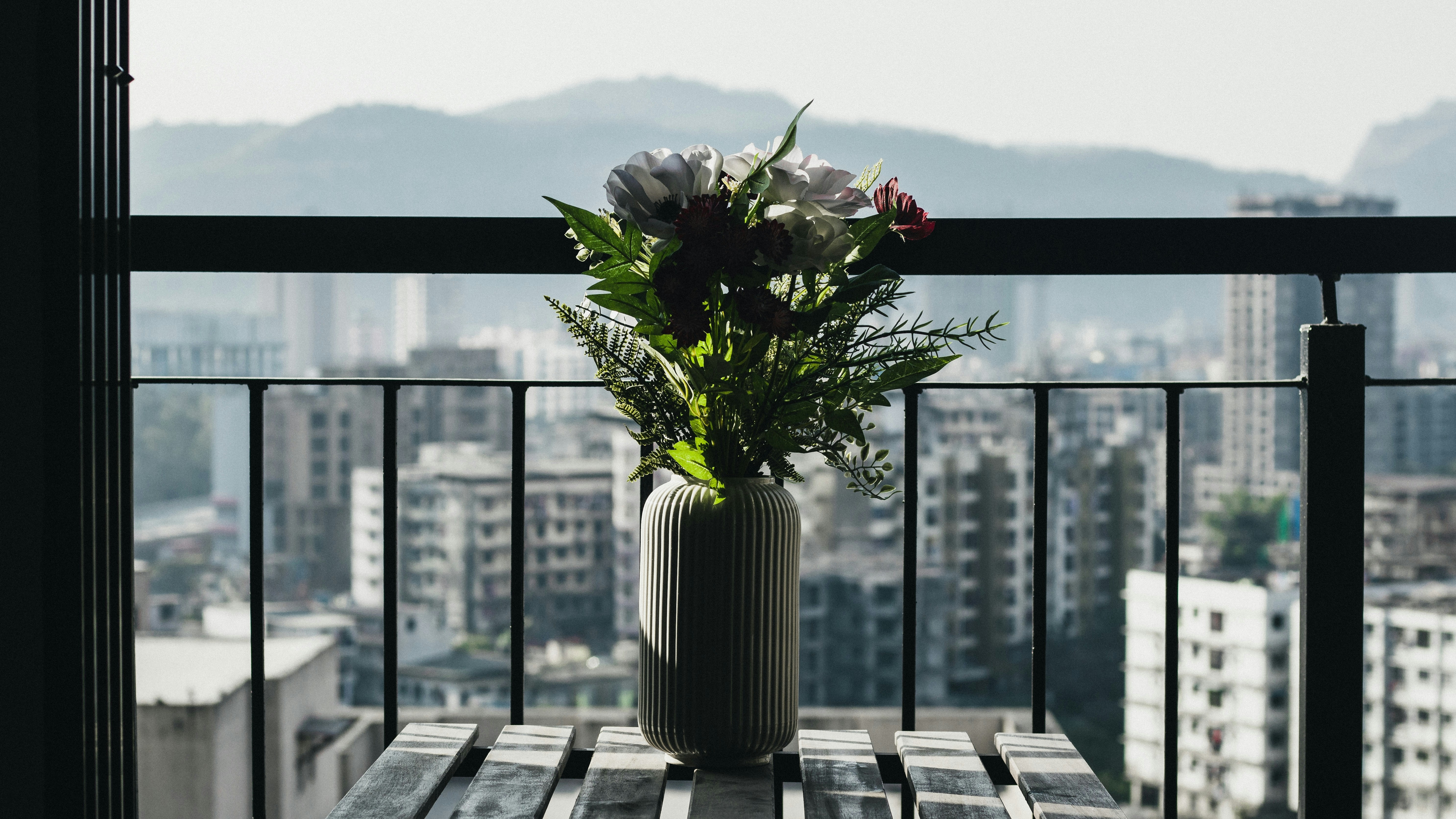 A vase filled with flowers sitting on top of a wooden table photo ...