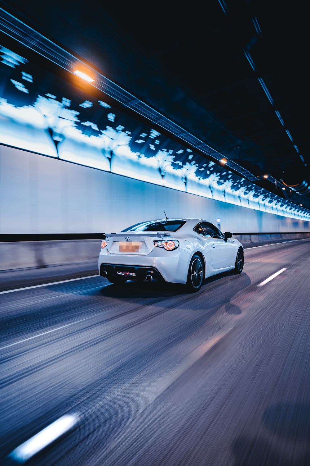 a white sports car driving down a highway