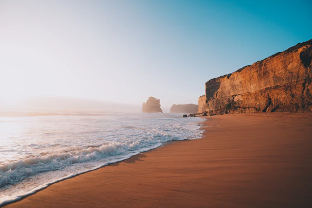 A panoramic view of a remote coastal headland bathed in soft golden light, emphasizing solitude and space.