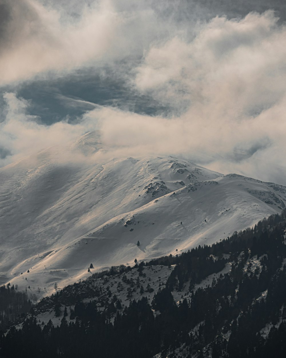 uma montanha coberta de neve sob um céu nublado