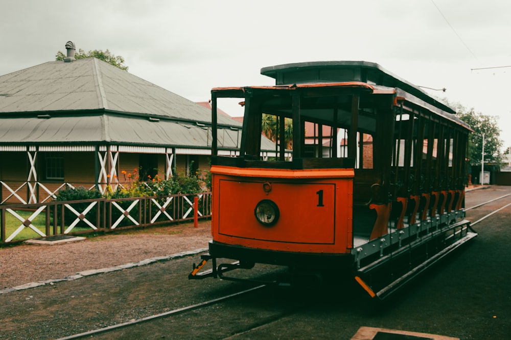 an orange trolley car on a city street