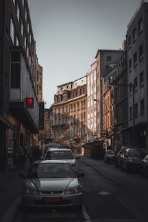 a car parked on the side of a street next to tall buildings