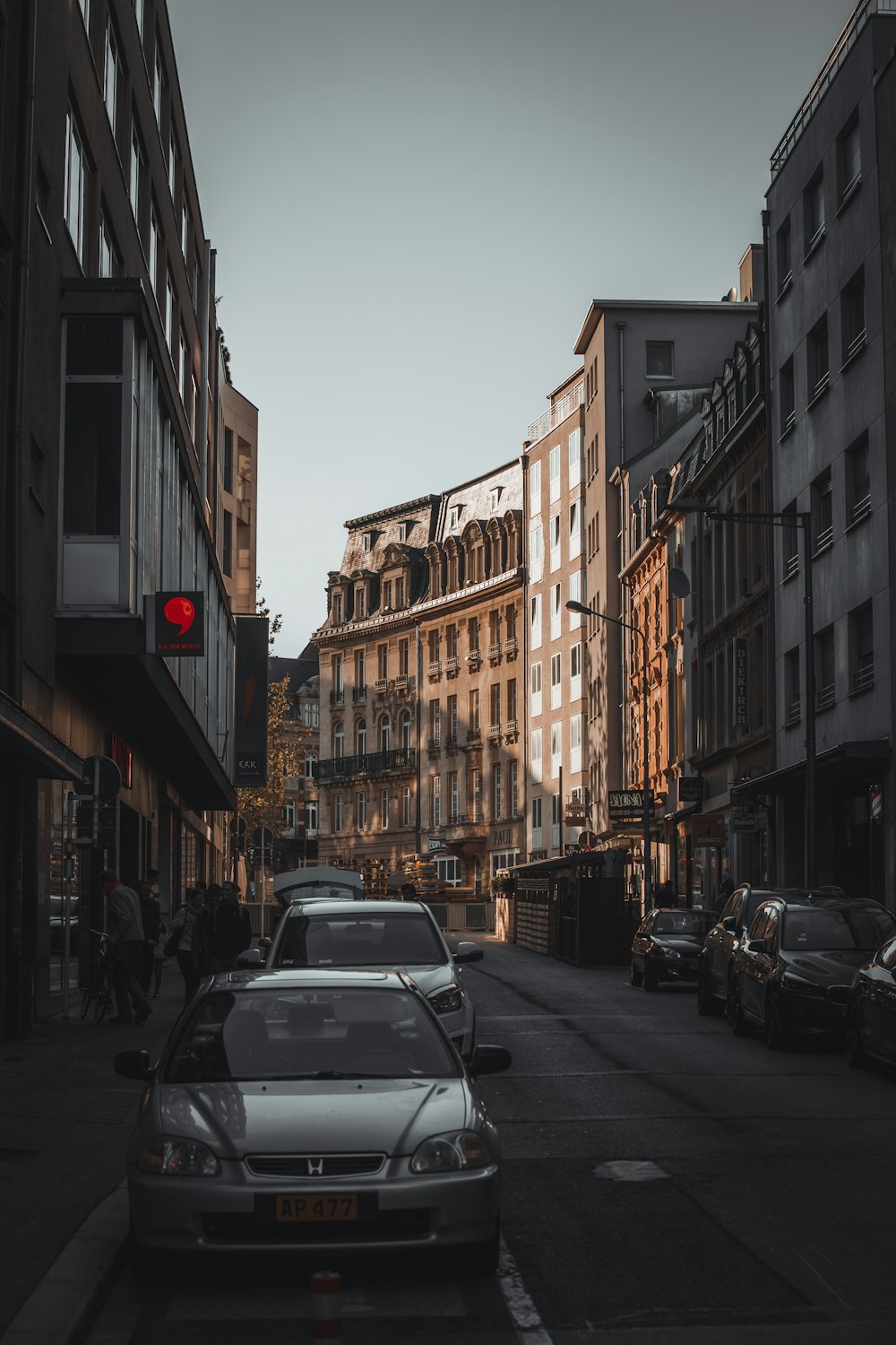 a car parked on the side of a street next to tall buildings