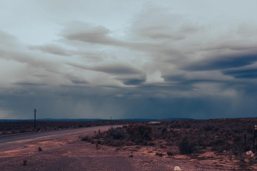 Una strada nel mezzo di un deserto sotto un cielo nuvoloso